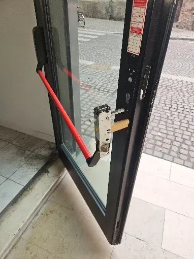 Lavoro di Eugenio a Canda: maniglione antipanico e serratura di una porta di negozio